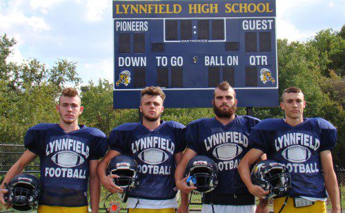 SPORTING NEW MOHAWKS, the Pioneer captains (from left) Cam Rondeau, Danny Sullivan, David Adams and Jon Knee pose in front of the new scoreboard at LHS Stadium. The first football home game of the season will be played in the new stadium on Friday, Oct. 10. (Tom Condardo Photo)