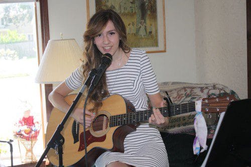 SINGER/SONGWRITER Katrina Gustafson, 16, performs her original song, "Everyday," in her home practice space. As a Top Ten finalist in the 92.5FM Music Matters contest, "Everyday" received air time on the radio this summer and could be named the grand prize winner next week. She released her first self-titled CD this spring. (Maureen Doherty Photo)