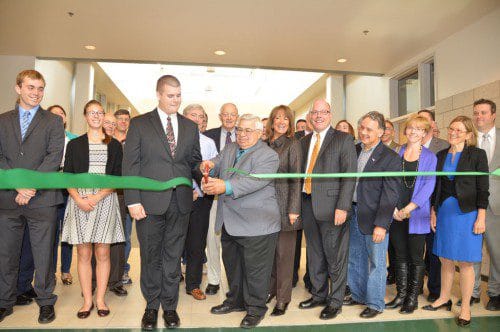 THE BIG MOMENT. Assisted by students, school administration, town and state officials, Chuck Carucci (center) Chairman of the Secondary Schools Building Committee, cuts the ceremonial ribbon for the grand opening of North Reading High School. (Bob Turosz Photo)