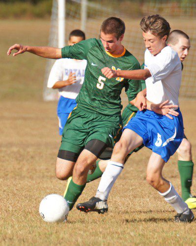 ROYAL ROUT. Hornet junior Tom Lewis (5) blocks his Georgetown opponent from the ball in North Reading's 3–0 win. (John Intorcio Photo)