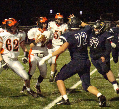 GREETINGS. Ipswich quarterback Vinny Martineau is about to meet up with the center of the Pioneer defensive line in Cam DeGeorge (72) and Steven White (77). Both linemen had sacks in the game.      (Tom Condardo Photo)