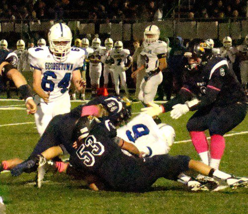 WELL DONE. Trevor Caswell (53) and Brenden Rothwell (54) bring down the Royals’ Ryan Sherman in first-quarter action. Jake Rourke (right) moves in to join the action. (Tom Condardo Photo)