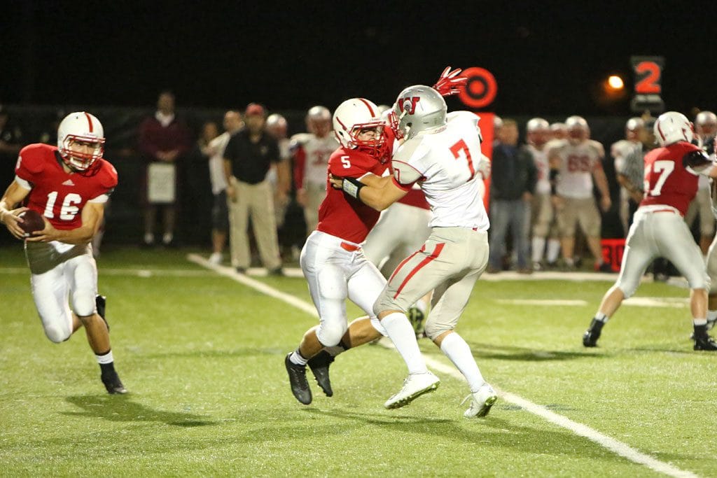 MELROSE'S MIKE Pedrini had four touchdowns for Melrose in their 42-21 win over Burlington last Thursday night on the road at Varsity field. Pedrini, pictured protecting Melrose quarterback Jake Karelas, has 7 touchdowns in two games, helping Melrose earn a 3-0 league record with Watertown on the horizon. (Donna Larsson photo)