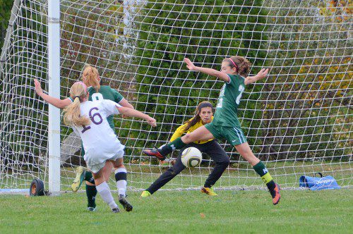 SENIOR CAPTAIN Kerri-Ann Donovan leaps in front of sophomore keeper Kat Hassapis in an attempt to block this Newburyport scoring attempt. (John Friberg Photo)