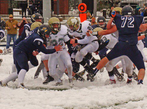 HITTING THE WALL. CJ Finn (11), Jake Rourke (6), Spencer Balian (76) and Cam DeGeorge (72) corral Hornet running back Matt McCarthy (25) at snowy Pioneer Stadium on Thanksgiving. (Tom Condardo Photo)