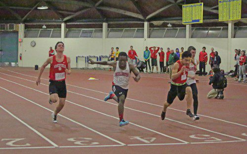 IN A DISPUTED outcome, Warrior Eric Chi (second from right) reached the tape at nearly the same time as Burlington’s Chenet Guerrier (second from left). If the Warriors are declared victors they will be league indoor track champs outright for the first time since the early 1970s. For full story and more photos, see Sports beginning on Page 11. (Donna Larsson Photo)