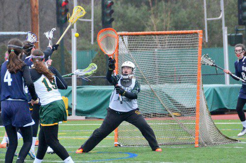 GIRLS LACROSSE GOALIE Liz Carlson, a junior, provides stout defense in goal for the Hornets. (John Friberg Photo)