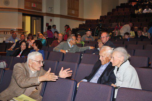 LONGTIME residents Tom Duggan (left) and John and Elaine Gilbertson chat during Thursday night’s session of Town Meeting while waiting for a quorum of voters to fill the Middle School auditorium. Only 130 voters showed up so the meeting was adjourned until next October. At the first session of Town Meeting on April 27, both Duggan and John Gilbertson spoke in favor of the town maintaining control of Centre Farm. (Maureen Doherty Photo)
