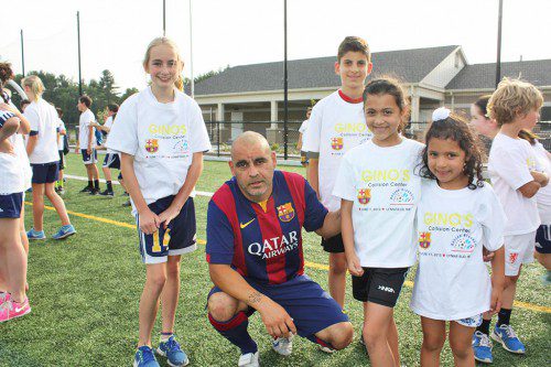 THE F.C. BARCELONA veteran players made each child feel special with one-on-one time prior to the game played against the Boston Braves F.C. Among the kids meeting players were, from left, Emily Storer, 11, George Nikolakopoulos, 12, Talia Bisbe, 8 and Liana Bisbe, 5.  (Maureen Doherty Photo)
