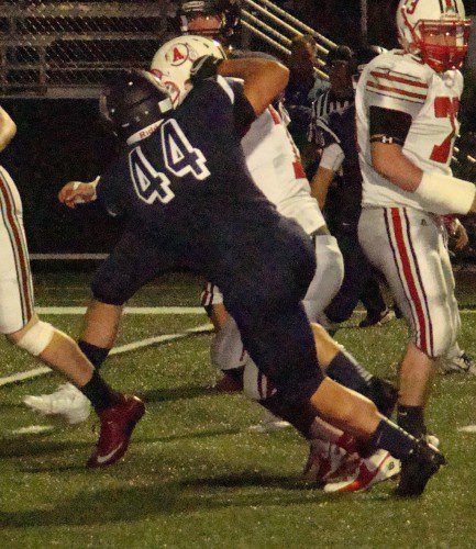 THAT'S A WRAP. Captain Drew Balestrieri (44) wraps up Amesbury running back Bradley Kelleher (17) after a short gain in Friday's 41-0 shutout. (Tom Condardo Photo)
