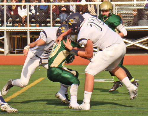 DUCK AND COVER. It was David vs. Goliath as Captain Cam DeGeorge (72) and Brendan Rothwell (54) engulf Hornet running back John Merullo (33) for a big loss in the first quarter. (Tom Condardo Photo)