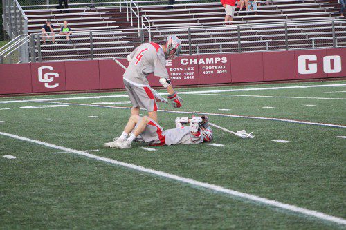 SENIOR AUSTIN Collard (#4) goes over to help up teammate Pat Leary after Wakefield’s 7-6 loss to Beverly in the Div. 2 North final on Saturday night at Memorial Stadium at Concord-Carlisle Regional High School. (Keith Curtis Photo)